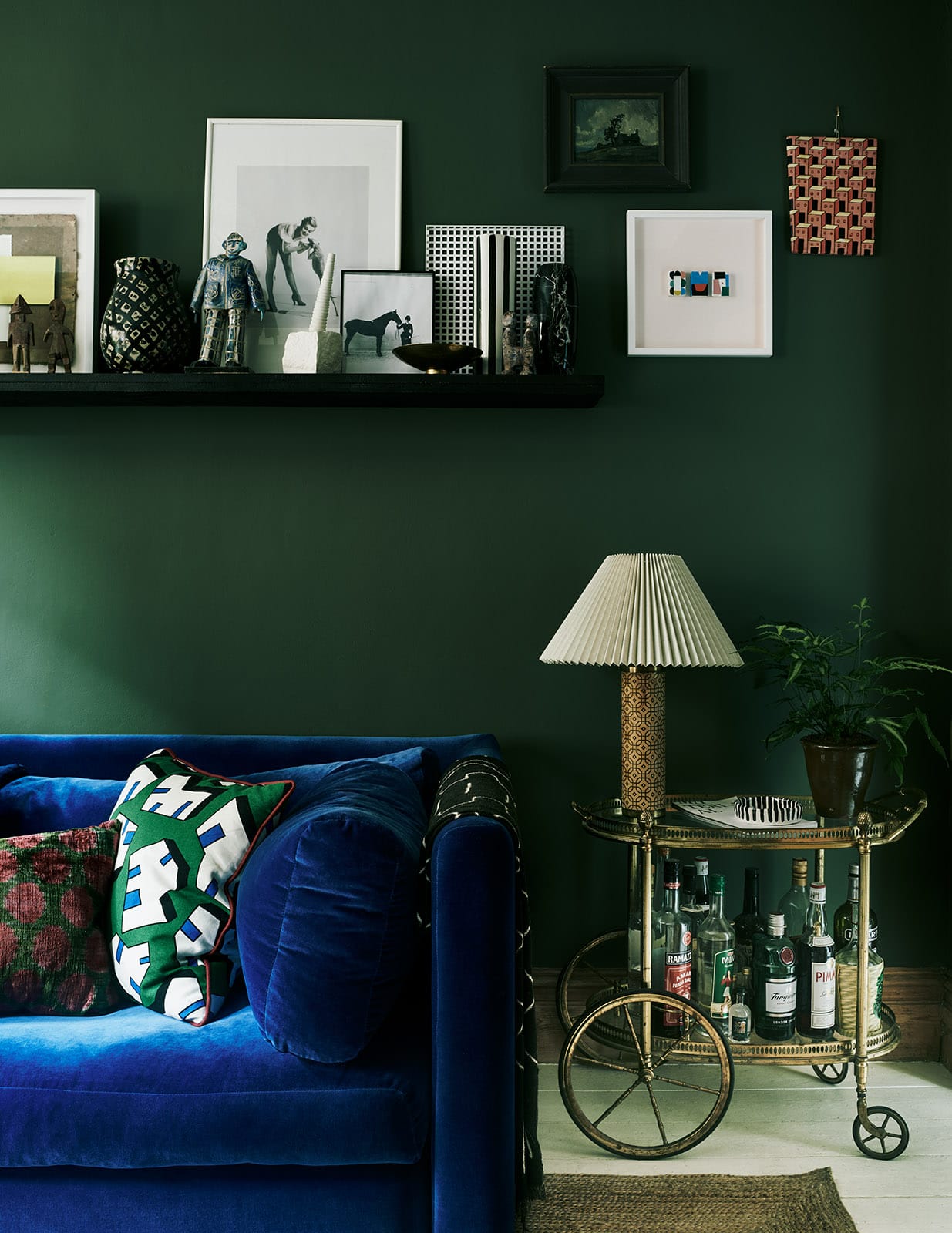 Jewel tone interior design Laura Fulmine, blue couch, emerald walls, bar cart. 