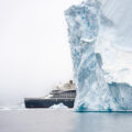 le commandant charcot Ponant ship behind an iceberg