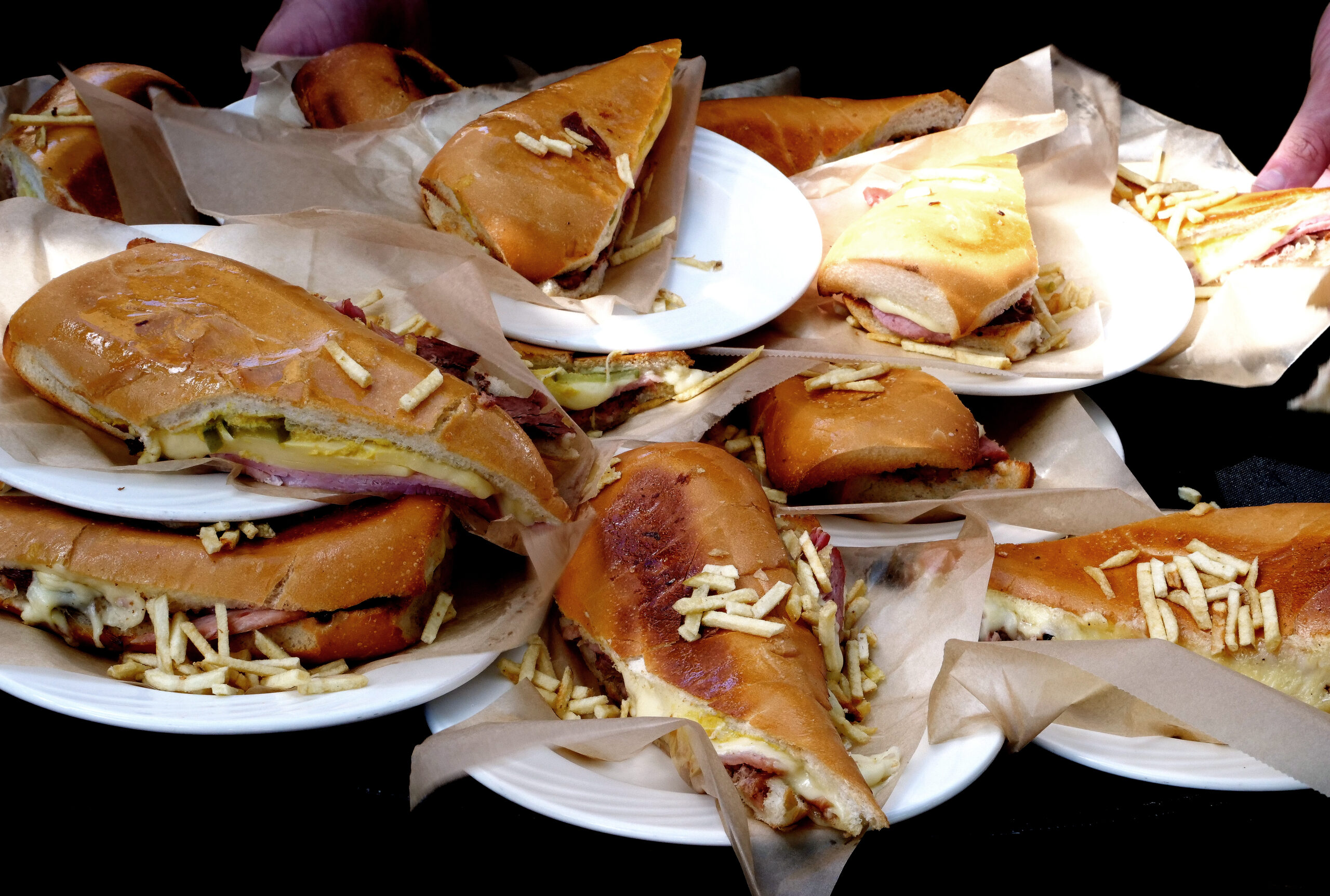 https://nuvomagazine.com/wp-content/uploads/2023/12/Old-Havana-Restaurant-Cubano-sandwich-with-ham-roasted-pork-swiss-cheese-pickles-and-mustard-scaled.jpg